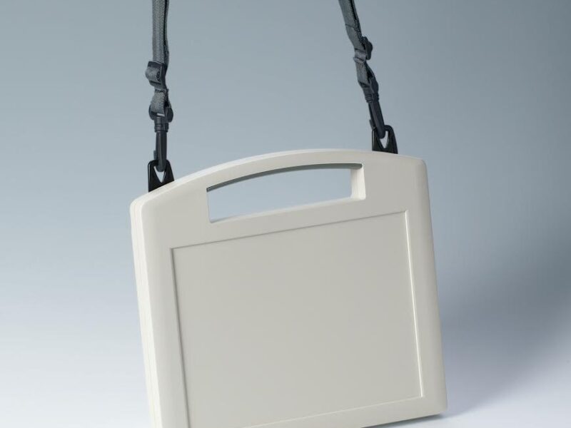Portable instrument enclosures with shoulder strap and brackets